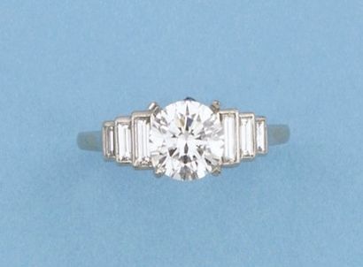 null Bague solitaire en platine ornée d'un diamant taillé en brillant épaulé de six...