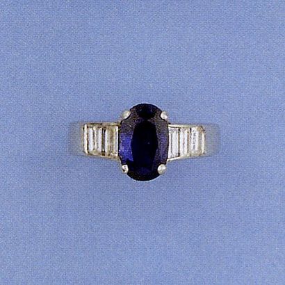 null Bague en or gris ornée d'un saphir ovale épaulé de six diamants baguette. Poids...