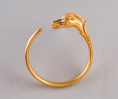 HERMES Paris Bracelet jonc ouvert métal doré, un embout figurant une tête de cheval....
