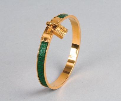 HERMES Paris Bracelet jonc «Kelly» en métal doré, serti de lézard vert et orné d?une...