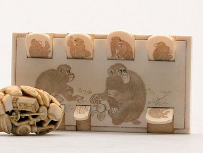 null COMPTE-POINTS en ivoire à décor finement gravé de singes dans des attitudes...