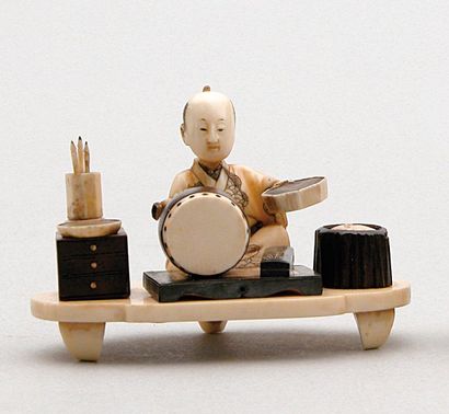null OKIMONO en bois, ivoire et corne brune représentant un artisan peignant un tambour....