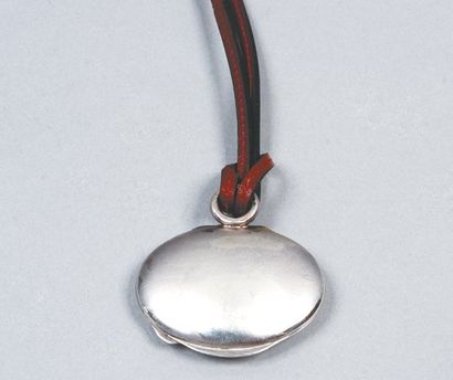 HERMÈS Paris Boîte à pillules en pendentif de forme ovale en argent retenu par un...