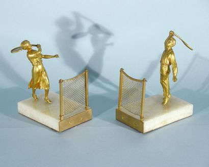 TENNIS Paire de serre-livre en bronze doré sur socle de marbre. Joueur et joueuse...