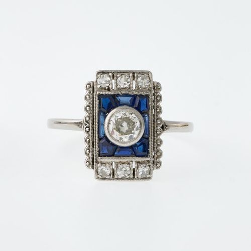 Art-Déco-Ring 高矩形头部。镶钻盾牌，中央是一颗约 0.25 克拉的盒镶明亮式切割钻石，周围是校准过的蓝宝石。轨道精良，尺寸 57。