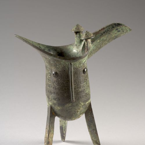 Null 青铜壶，中国，可能是商代晚期-周初（公元前11-10世纪）。 
壶身有三个刀形脚，壶身刻有饕餮面具，背景是古代图案（卷轴），壶把上有一个饕餮头，壶嘴两&hellip;