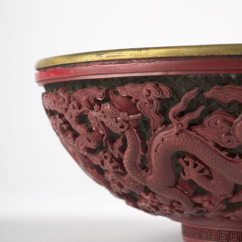 Null 罕见的帝国红釉碗，中国，清朝，乾隆时期（1736-1795年） 
半球形，靠在装饰有希腊人的小脚上，边缘精雕六条龙在云中游动，内部衬有一个铜碗；小的修&hellip;