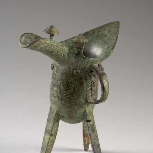 Null 青铜壶，中国，可能是商代晚期-周初（公元前11-10世纪）。 
壶身有三个刀形脚，壶身刻有饕餮面具，背景是古代图案（卷轴），壶把上有一个饕餮头，壶嘴两&hellip;