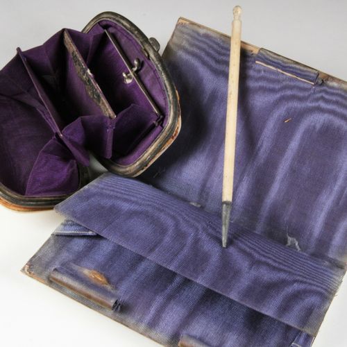 Null 套装包括一个带夹层的钱包和一个笔记本及其象牙色的手写笔。它们在一个多裂纹的卷轴中装饰有两个叶子和花的奖章，并以紫色丝绸为衬里（磨损）。小册子的尺寸。长&hellip;
