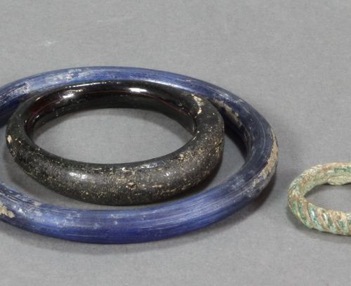 ARCHÄOLOGIE 两个手镯和一个指环。分别是亚光蓝、亮光黑和亚光绿的玻璃。罗曼(?)。直径7（蓝色），4.5（黑色）和2.3（绿色）厘米。(690)