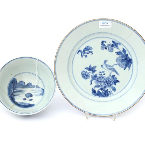 Null 一个19世纪的中国蓝瓷碗，上面有玩耍的男孩，一个18世纪的中国蓝瓷盘，上面有一只鸟在树枝上的装饰。两者都被损坏。碗的直径为14.5厘米。