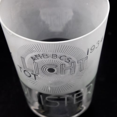 Null 一个部分缎化的透明玻璃花瓶，黑色玻璃底，上面有文字："A.N.B.C.S. Licht tot Duister 1894-1934"，设计者Elias&hellip;