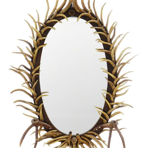Null Grand miroir ovale, XXe s., orné de bois de cervidés factices, 158x112 cm