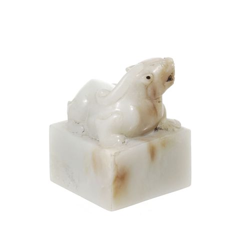Null A pale jade seal, China, surmounted by a reclining Buddhist lion, 5 cm high