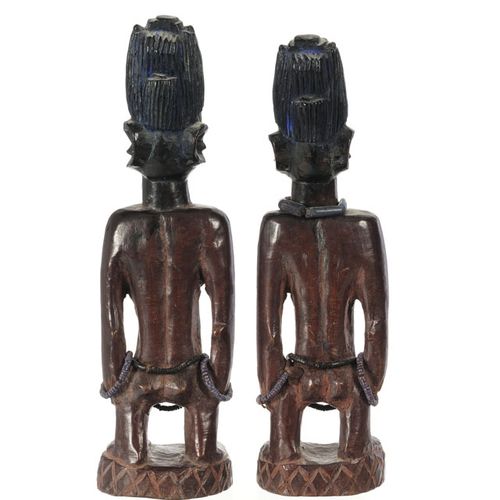 Null 一对伊贝吉约鲁巴女性雕像，Oyo/Oshogbo地区，硬木，有深棕色的铜锈，靛蓝颜料和玻璃珠，放在一个圆形的基座上，装饰有刻痕和交叉的图案，精致的头饰&hellip;