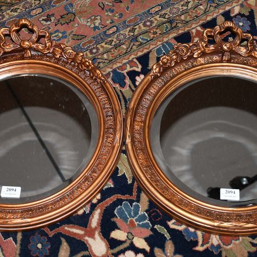 Paire de miroirs ronds en stuque doré au noeud Louis XVI 
Hauteur : 47 cm.