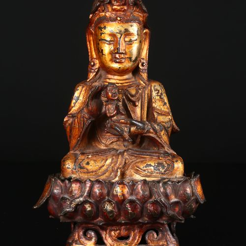 A Gilt Bronze Figure of Guanyin 鎏金观音铜像 中国，明朝晚期，17世纪 观音菩萨坐在莲花底座上，头戴华丽的头饰，面部表情安详，双&hellip;