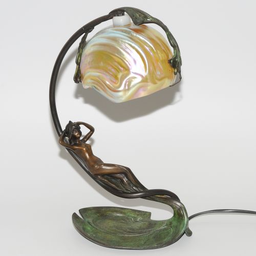 Nach C. Bonnefond 台灯。1900年左右，铜质底座，形状为女人的裸体，带有叶子形状的架子。鹦鹉螺形状的珍珠母斑斓玻璃制成的灯罩。脚上有标记："C&hellip;