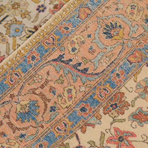 TÄBRIS 波斯西北部，约1910年，粉彩地毯。整个米色的内场都有丝状的棕榈花和藤蔓的装饰，无限的重复。2个花色的浅蓝色次要边框包围着优雅的粉红色主边框，还装&hellip;
