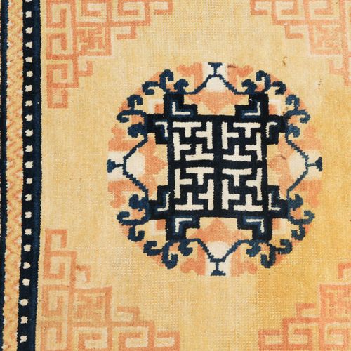 Ning-Hsia Z蒙古，约1900年。 寺庙地毯。在黄色的中央场地上有一个圆形的奖章，中央有一个深蓝色的卐字图案，两边是4个蜿蜒的角形饰条。一条深蓝色的珠子&hellip;