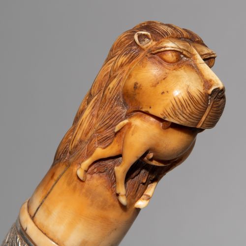Messer, Pishkabz 印度-波斯，19世纪。 雕刻的腿部鞍座：狮子头，口中有一只小羚羊。银质手镯，有花卉装饰，T形单刃刀Wootz，严重腐蚀。木制刀&hellip;