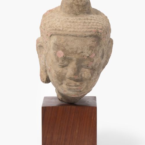 Buddhakopf 佛头

泰国。在Dvaravati（公元6-11年）的风格中。红色砂岩。头上有风格化的钮扣状卷发和火焰。高25厘米。有木质底座。