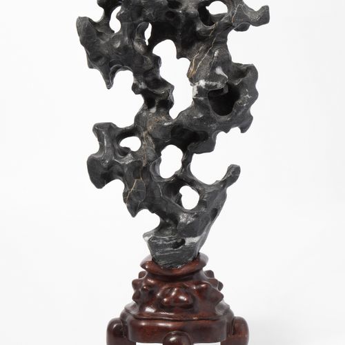 Gelehrtenstein 学者之石

中国，20世纪。 黑色石头与白色区域。安装在一个木质底座上。高46厘米。