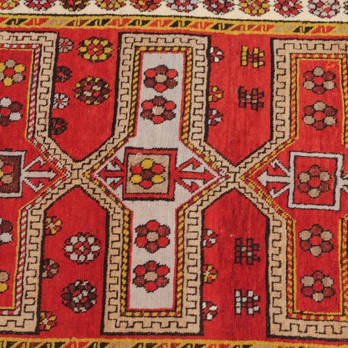 KAZAK 卡扎克

南高加索地区，约1920年。浅红色的场地上有5个交替的卡图徽章，两侧是风格化的动物、花朵和其他哈萨克元素。白色的主边框上有单独绘制的棕榈花&hellip;