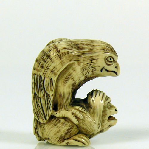 Null Netsuke (Japan, c. 1900) ''Eagle sitting on monkey''; ivory, incised and da&hellip;