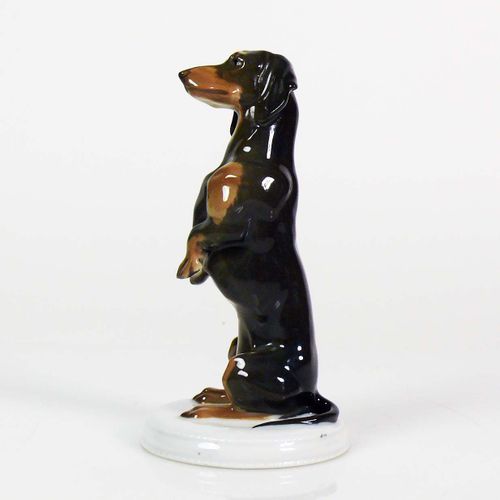 Null 腊肠犬（罗森塔尔，约1920年）直立，呈雄性姿势；棕色釉下彩；白色圆形底座上；底部有标记；高：15厘米；未损坏