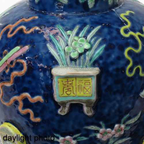 Null 珐琅彩花瓶连盖
深蓝色地，装饰有中国古物，庙宇狮子盖，高39厘米，已修复。