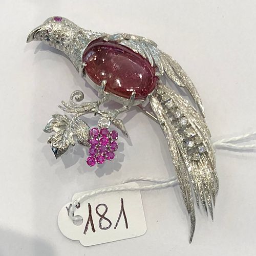Null 重要的白金胸针，代表一只天堂鸟，身体上镶嵌着一颗凸圆形的大红宝石，尾巴和脖子上镶嵌着钻石，它栖息在一个镶嵌着红宝石和钻石的藤蔓上，26.8克