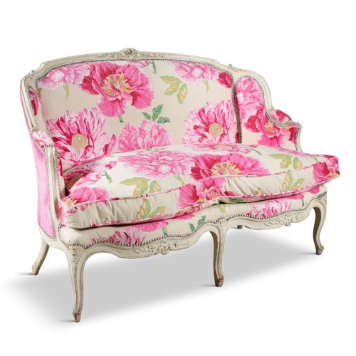 Null 维多利亚时代的女式沙发，奶油色的框架上雕刻着花朵和叶子的装饰，用奶油色的布料装饰着粉色的牡丹花，还有长的乳鸽垫。133 x 95厘米
