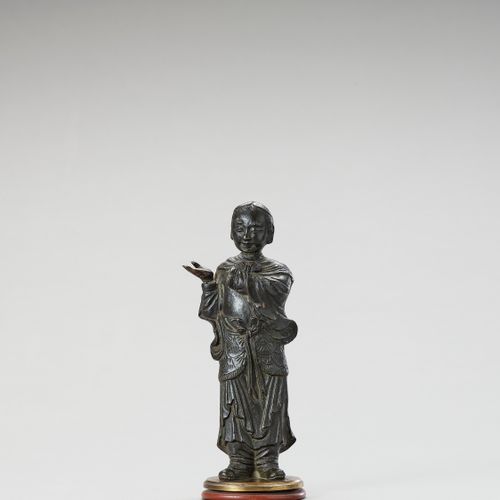 A BRONZE FIGURE OF A LUOHAN, MING 罗汉铜像，明
中国，明朝（1368-1644），17世纪。描绘了一个站立的罗汉指向他的右边。&hellip;