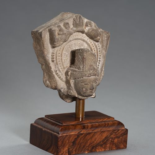 AN INDIAN STONE HEAD OF BUDDHA 印度石雕菩萨头像
印度北部，15世纪。石头上精雕细刻着一个菩萨头像，后面的宝座部分显示了曼陀罗和两&hellip;