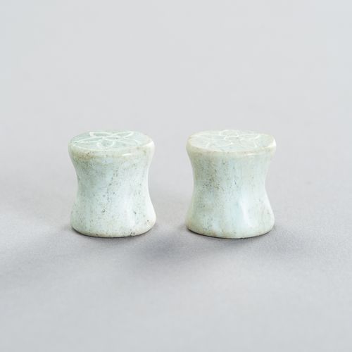 A PAIR OF STONE EARPLUGS 一对石制耳坠
东南亚，20世纪初或更早。两件都是用洗净的绿色石头雕成的，两面都刻有简单的花纹。

状况。 状态&hellip;