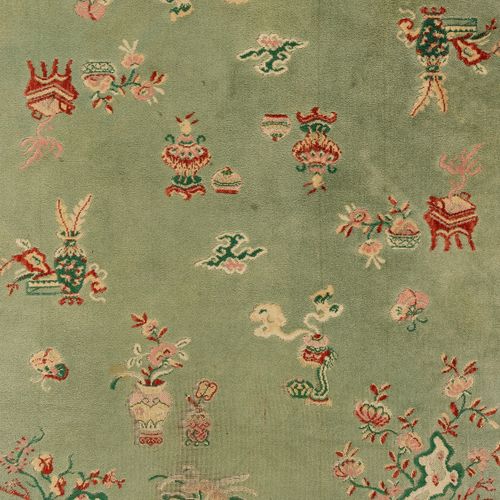 A LARGE CHINESE WOOLLEN RUG 一个大的中国羊毛地毯
中国，1920-1930。精心编织的地毯上散布着吉祥物和佛教符号，边上是装满鲜花的&hellip;