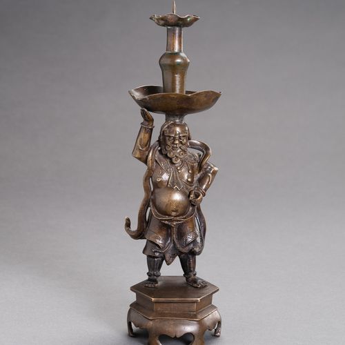 A BRONZE `FOREIGNER´ CANDLESTICK 铜制 "外国人 "烛台
中国，明末（1368-1644）。大胡子的外国人被铸在一个六角形的底座&hellip;