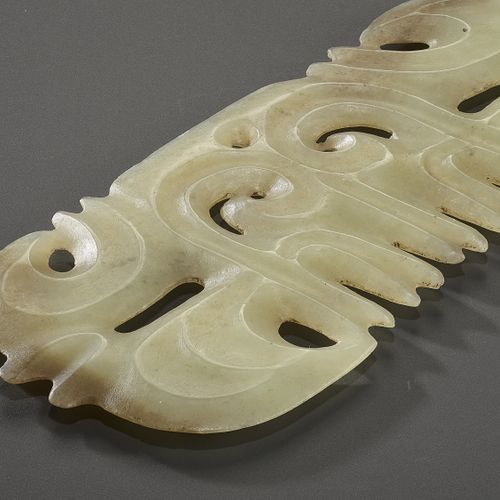 A LIGHT YELLOW JADE ‘TOOTHED’ ORNAMENT WITH MASK MOTIF 浅黄色玉石 "齿 "形挂件，带面具图案
玉。中国，&hellip;