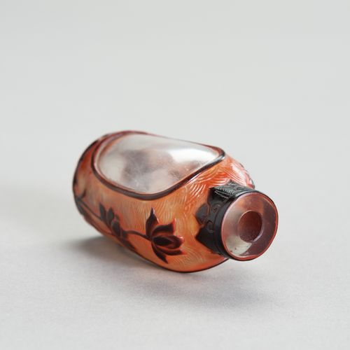 AN OVERLAY GLASS SNUFF BOTTLE 一个套色玻璃鼻烟壶
中国，19世纪。叠层玻璃鼻烟壶有一个突出的脚环和一个圆柱形的颈部。它是用透明的玻&hellip;