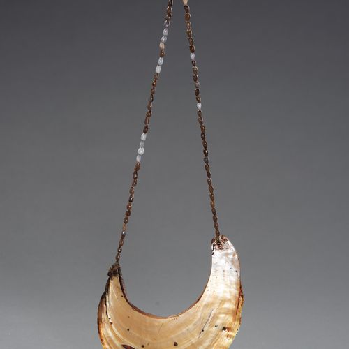 A TRIBAL SHELL NECKLACE 一个部落的贝壳项链
大洋洲，19-20世纪。这条民族项链由小贝壳支撑着一个大贝壳胸饰。

状况。 状况良好，贝壳&hellip;