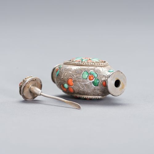 AN EMBELLISHED SILVER SNUFF BOTTLE 一个有纹饰的银质鼻烟壶
中国，19世纪。壶身刻有细微的花叶装饰，上面整齐地镶嵌着珊瑚和绿松&hellip;