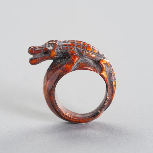 A TRIBAL `COCODRILE´ IVORY RING 一个部落的 "鳄鱼 "象牙戒指
东南亚，19世纪或更早。这个雕刻着鳄鱼的民族戒指显示出美丽的深琥&hellip;