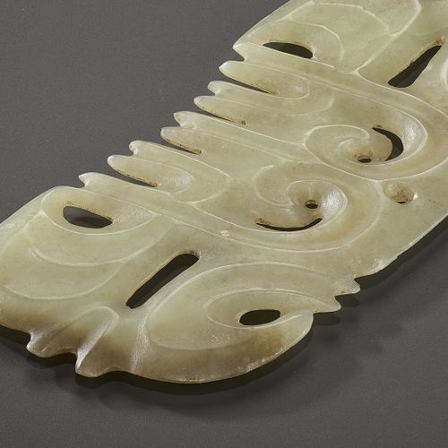 A LIGHT YELLOW JADE ‘TOOTHED’ ORNAMENT WITH MASK MOTIF A LIGHT YELLOW JADE ‘TOOT&hellip;