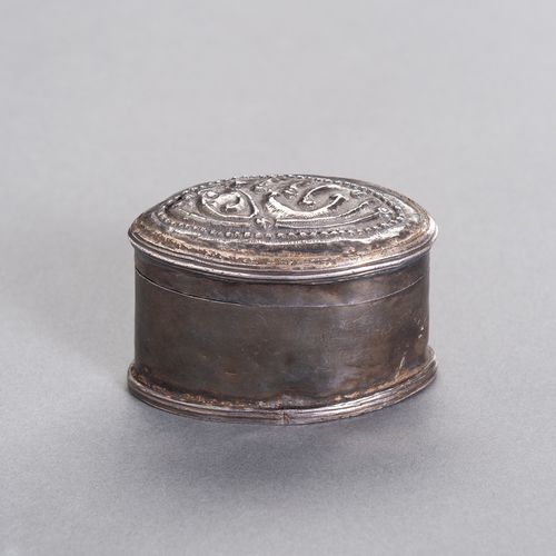 AN OVAL-SHAPED SILVER MEDICINE BOX 椭圆形银质药箱
缅甸/缅甸，19世纪。椭圆形的银盒盖上有精美的浮雕图案。

状况。 有凹痕&hellip;