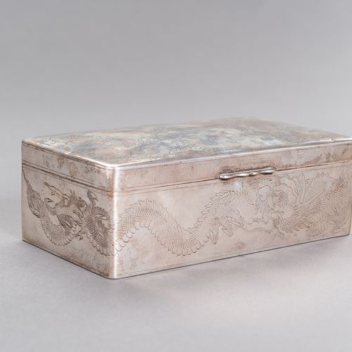 A “HAPPY MEMORIES” SILVER BOX 一个 "快乐的记忆 "银盒
中国，约1920年。盒盖上和窄边上整齐地刻着一条雄伟的龙，铰链盖的中心刻&hellip;