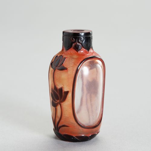 AN OVERLAY GLASS SNUFF BOTTLE 一个套色玻璃鼻烟壶
中国，19世纪。叠层玻璃鼻烟壶有一个突出的脚环和一个圆柱形的颈部。它是用透明的玻&hellip;