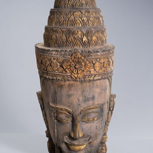 A LARGE WOOD HEAD OF BUDDHA 大型木制佛像
柬埔寨，乌东克，后吴哥时期（1618-1863）。戴着头饰和雕刻有花纹的乌斯尼沙，面容安详&hellip;