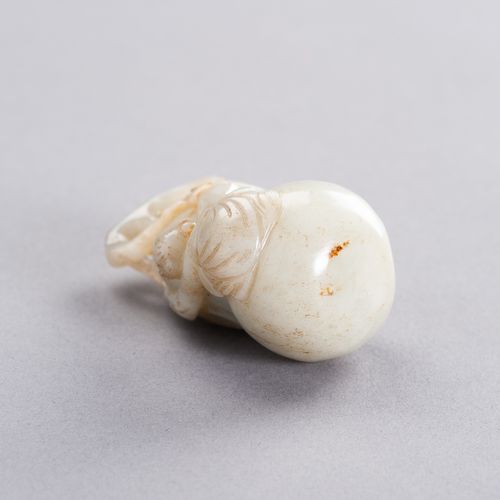 A CELADON JADE PENDANT DEPICTING A BOY CLIMBING A GIANT DOUBLE GOURD, LATE QING &hellip;