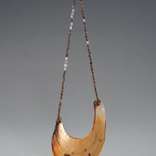 A TRIBAL SHELL NECKLACE 一个部落的贝壳项链
大洋洲，19-20世纪。这条民族项链由小贝壳支撑着一个大贝壳胸饰。

状况。 状况良好，贝壳&hellip;